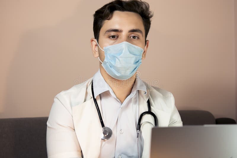 Male Doctor Using Laptop Computer With White Mockup Screen Technology