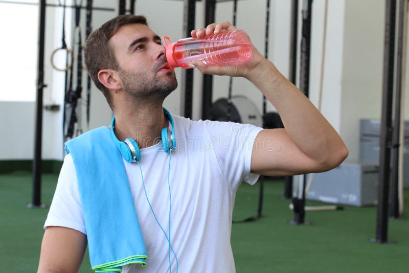 Male drinking water at the gym.