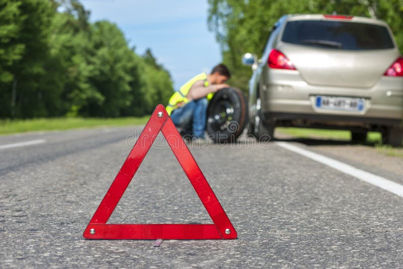 Male driver with spare wheel on the roadside royalty free stock photography Male driver with spare wheel on the roadside royalty free stock photography