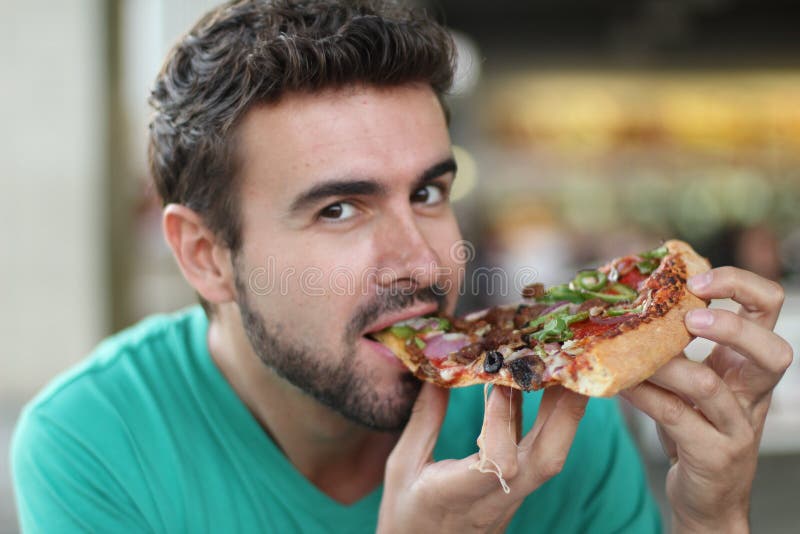 Male eating a yummy slice of fresh pizza stock photo