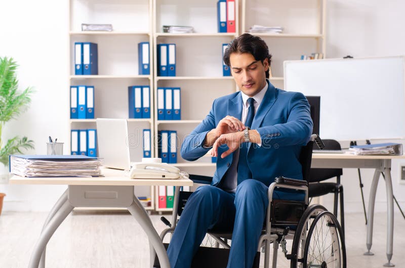 The Male Employee in Wheelchair Working at the Office Stock Photo