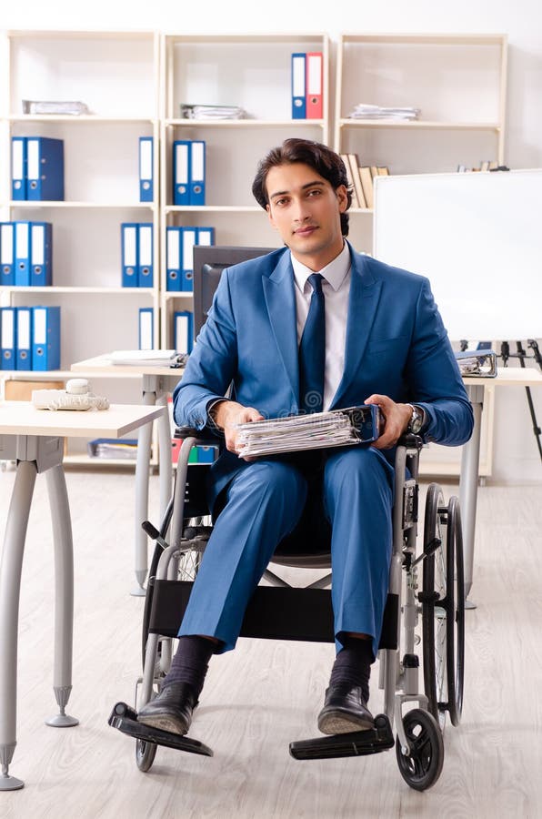The Male Employee in Wheelchair Working at the Office Stock Photo