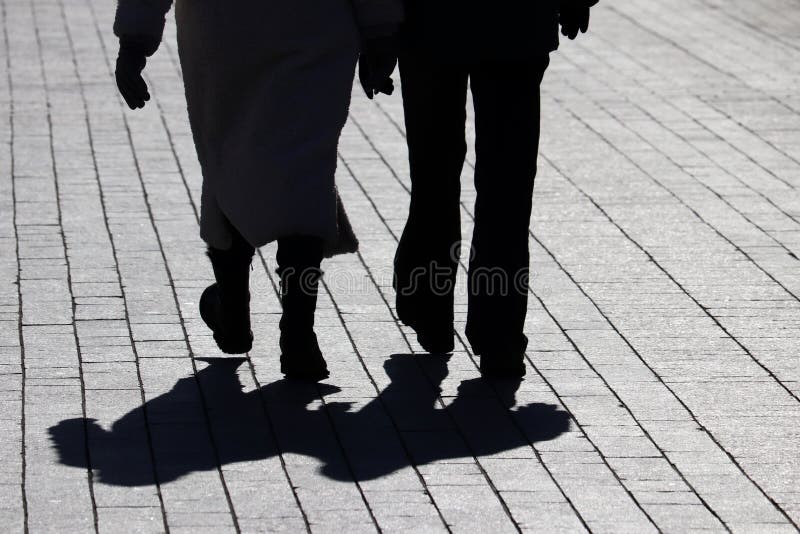 Running young couple in shadows with sun light behind them while wearing  black and grey jogging, Stock Photo, Picture And Royalty Free Image.  Pic. WE144805