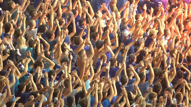 Male football supporters raised hands, organized clap, cheer for national team