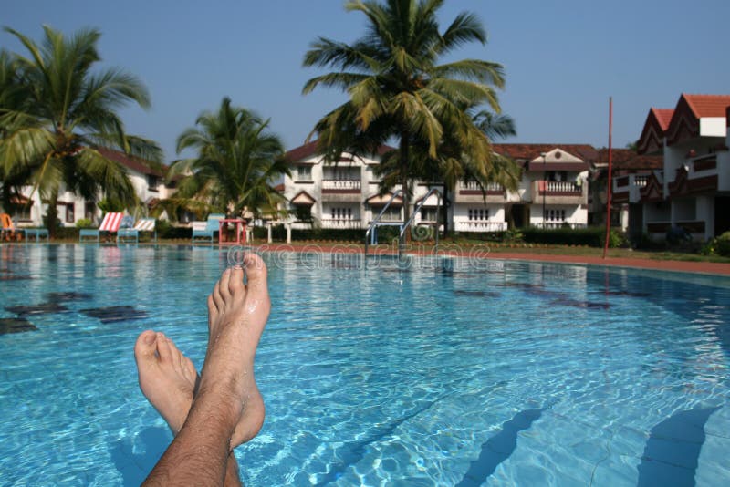 Male foots and swimming pool