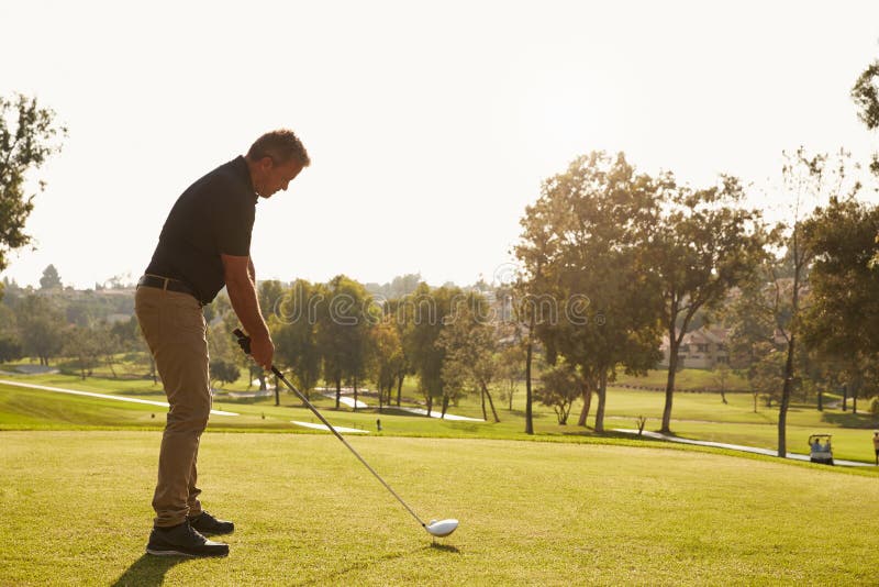 Male Golfer Lining Up Tee Shot On Golf Course