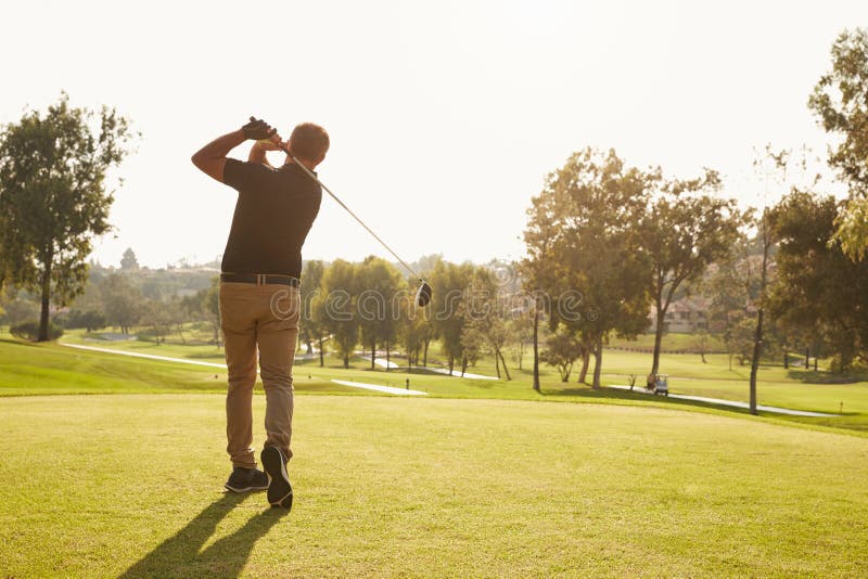 Male Golfer Lining Up Tee Shot On Golf Course