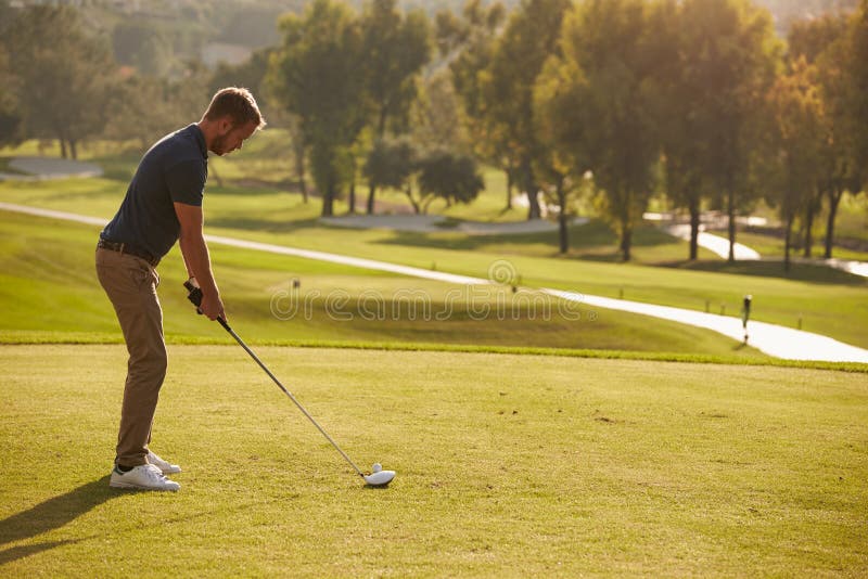 Male Golfer Lining Up Tee Shot On Golf Course