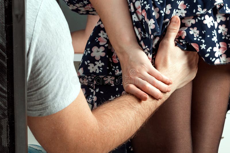 A Male Hand Climbs a Girl Under a Skirt