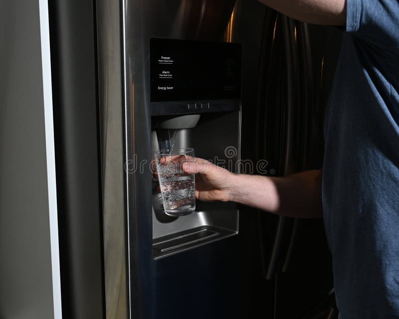 Unrecognizable Man Filling Glass From Refrigerator Water Dispenser