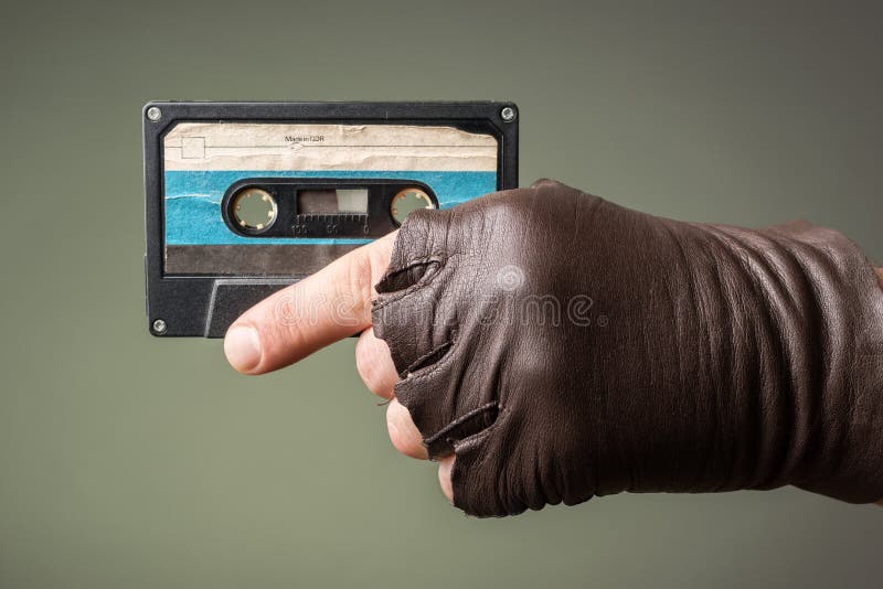 Male hand with glove holding an old music tape