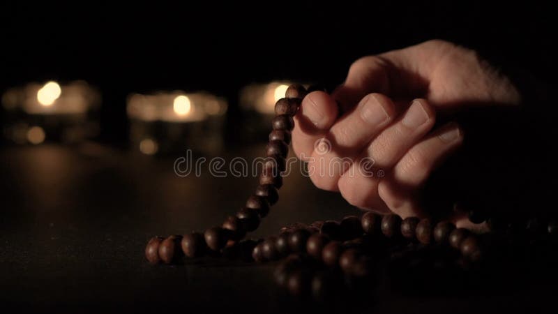 Male hand holding rosary beads