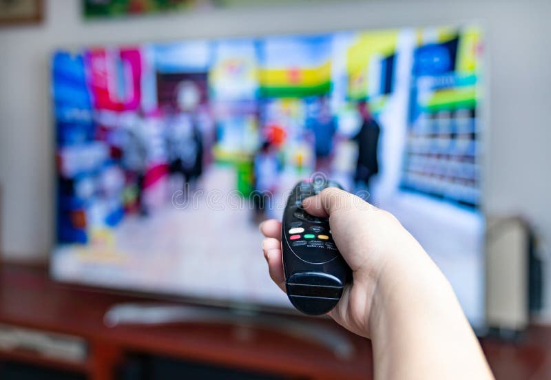 Male Hand Holding TV Remote Control for Change Program Stock Photo