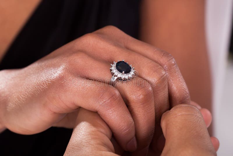 Male Hand Inserting Ring into a Finger Stock Photo Image of