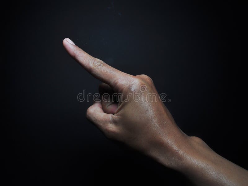 Male hand pointing isolated on black background. Body part gesture