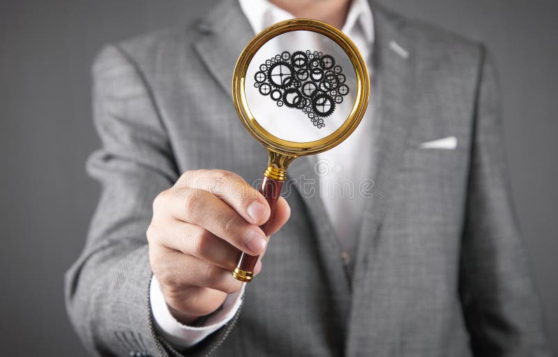 Male Hand Showing Magnifying Glass with a Human Brain Stock Photo