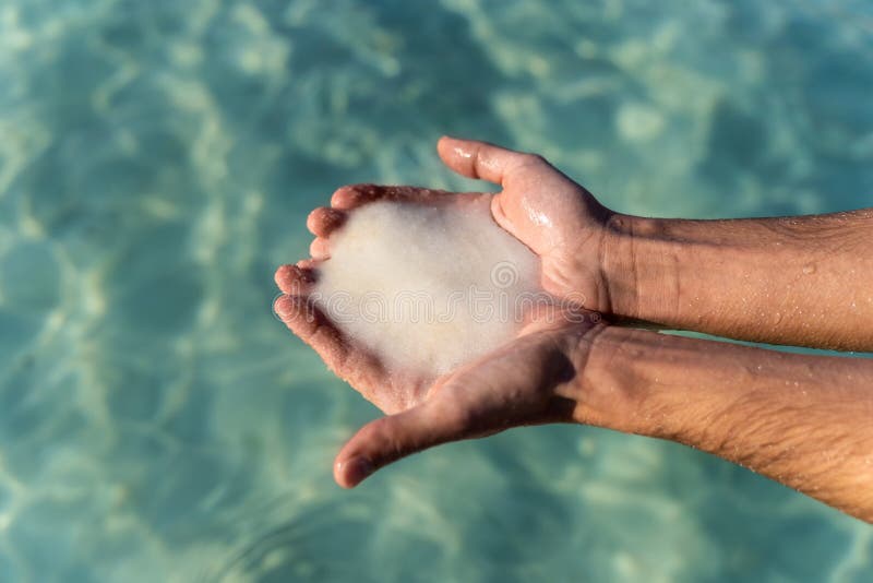 Male hands holding salt from the dead sea