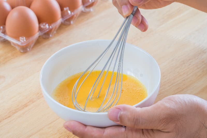 Male hands mixing eggs in bowl stock photos Male hands mixing eggs in bowl stock photos