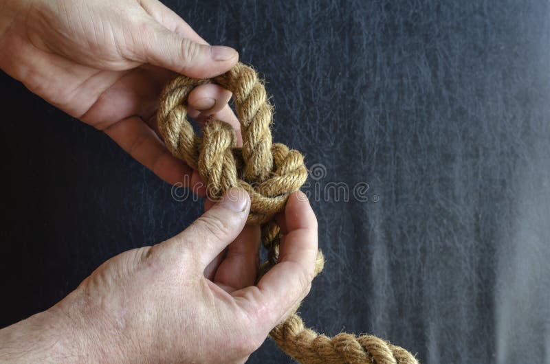 Male hands tie a knot on a rope