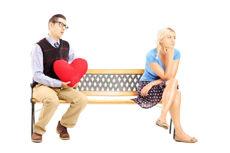 Male holding a red heart and disappointed female sitting