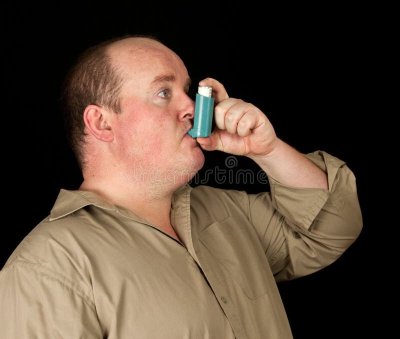 Male with inhaler asthma on black background royalty free stock image