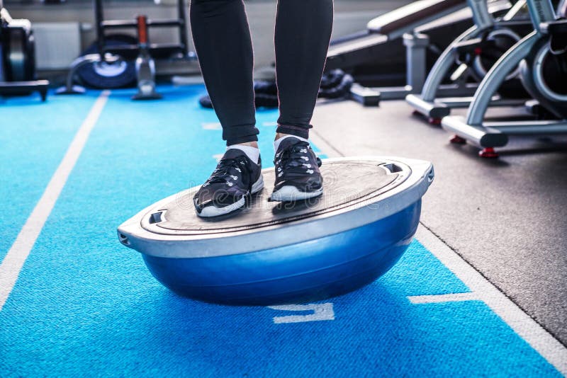 Male legs  on bosu ball in fitness studio