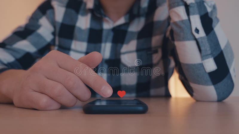 Male looks through Instagram page on Mobile Phone, white and red hearts floating out of smart phone