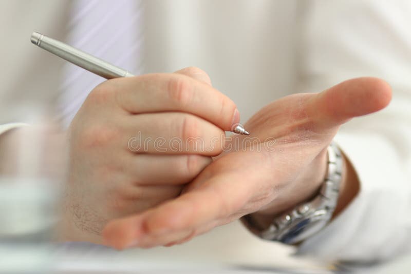 Male make x cross note with silver pen at his arm stock photos Male make x cross note with silver pen at his arm stock photos