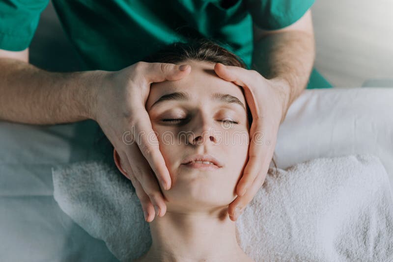 Male Massage Therapist Makes Face Massage To A Young Beautiful Woman 