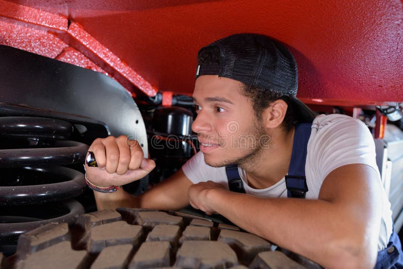 Male mechanic using torch to inspect vehicle stock images Male mechanic using torch to inspect vehicle stock images