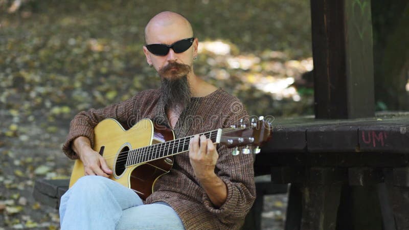 Male musician playing guitar outdoors