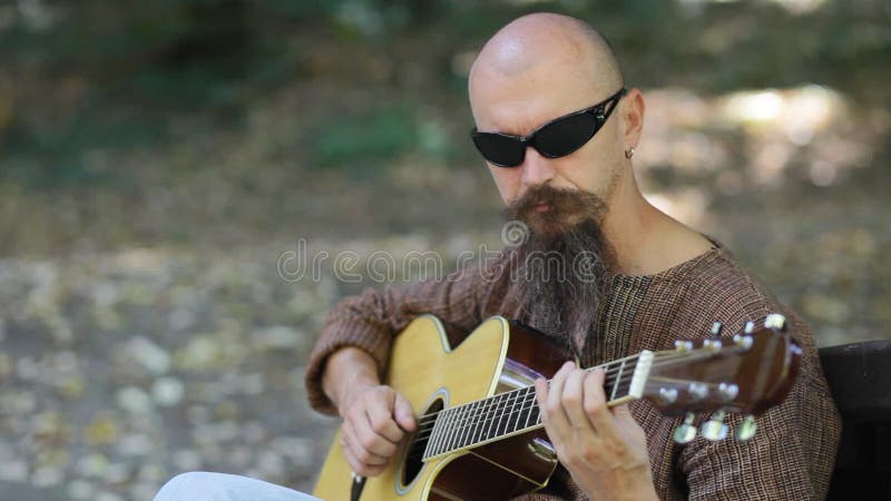 Male musician playing guitar outdoors