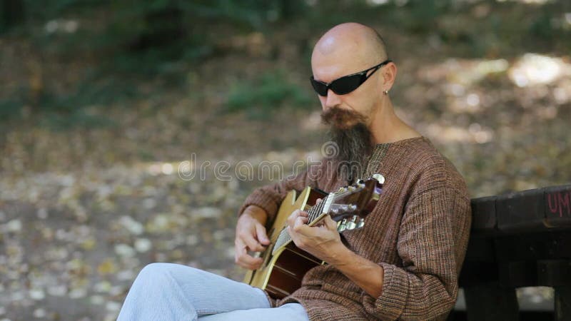 Male musician playing guitar outdoors