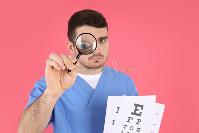 Male Nurse Holds Magnifier and Vision Test on Pink Background Stock