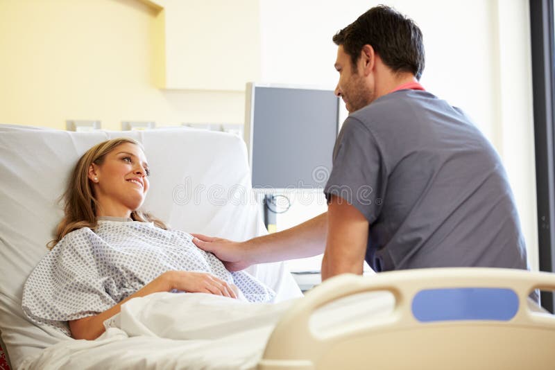 Male Nurse Talking With Female Patient In Hospital Room Stock Image