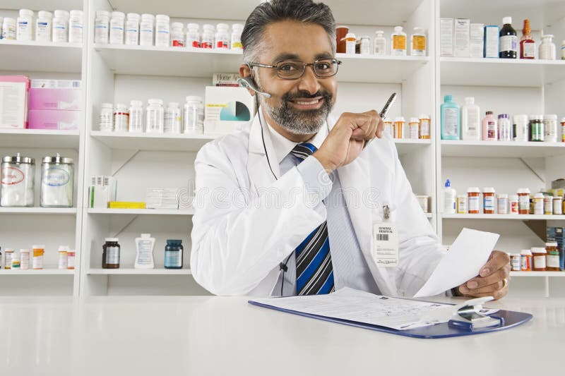 Male Pharmacist Working In Pharmacy