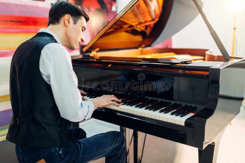Male pianist at the classical black grand piano royalty free stock images