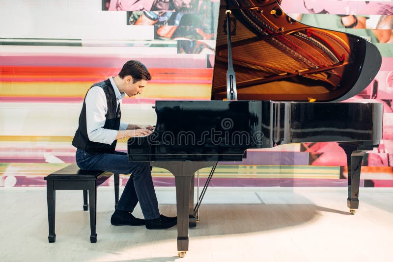 Male pianist practicing composition on grand piano royalty free stock photography
