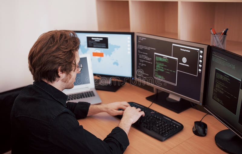 Male programmer working on desktop computer with many monitors at office in software develop company. Website design stock images Male programmer working on desktop computer with many monitors at office in software develop company. Website design stock images