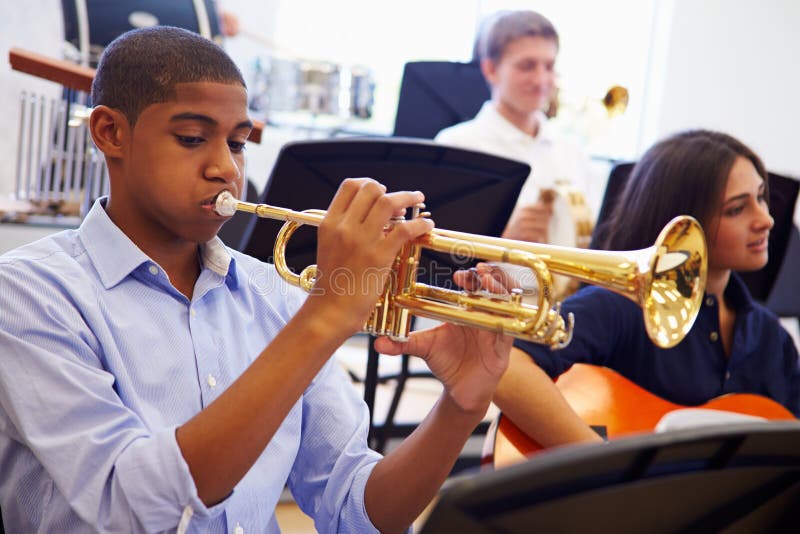 Male Pupil Playing Trumpet In High School Orchestra