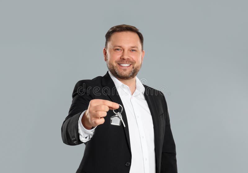 Male Real Estate Agent Holding Key on Grey Stock Image Image of