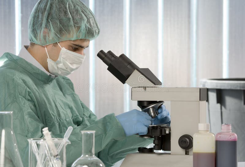 Male researcher looking through a microscope in a stock photography