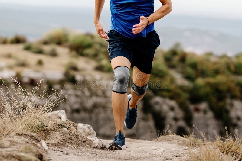 Male Runner with Knee Pads Running on Mountain Trail Stock Image