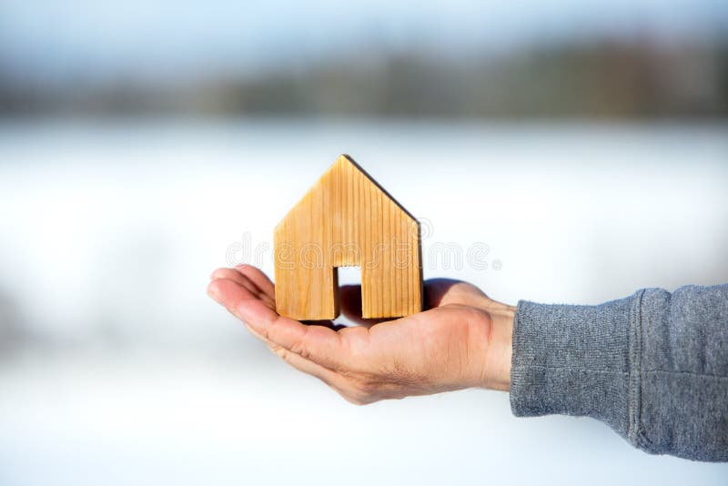 MaleÂ´s Hand holding a wooden house, planning for the future, real estate