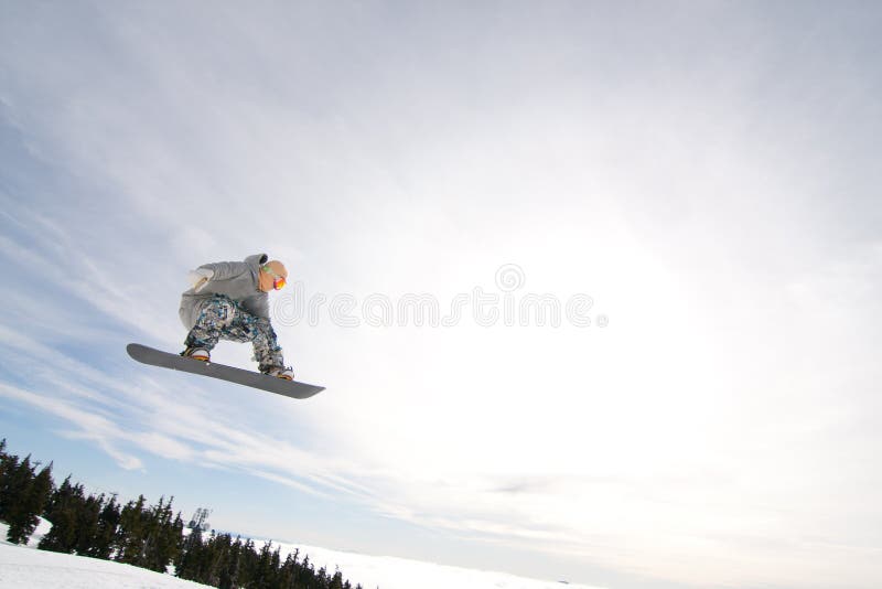 Male Snowboarder Catches Big Air on a Bright Sunny Day. Male Snowboarder Catches Big Air on a Bright Sunny Day.