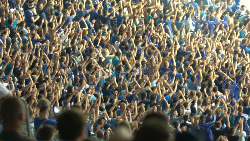 Male supporters clapping hands, cheering for national football team at stadium