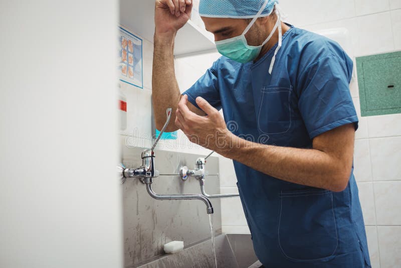Male Surgeon Washing Hands Prior To Operation Using Correct Technique