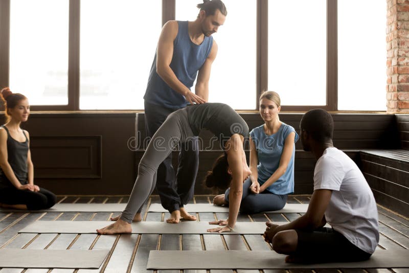 Male teacher assisting woman doing yoga bridge exercise on mat royalty free stock image Male teacher assisting woman doing yoga bridge exercise on mat royalty free stock image