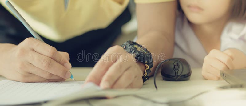 Male teacher in yellow shirt going around class, helping and che stock photo Male teacher in yellow shirt going around class, helping and che stock photo