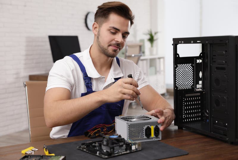 Male Technician Repairing Power Supply Unit at Table Stock Image